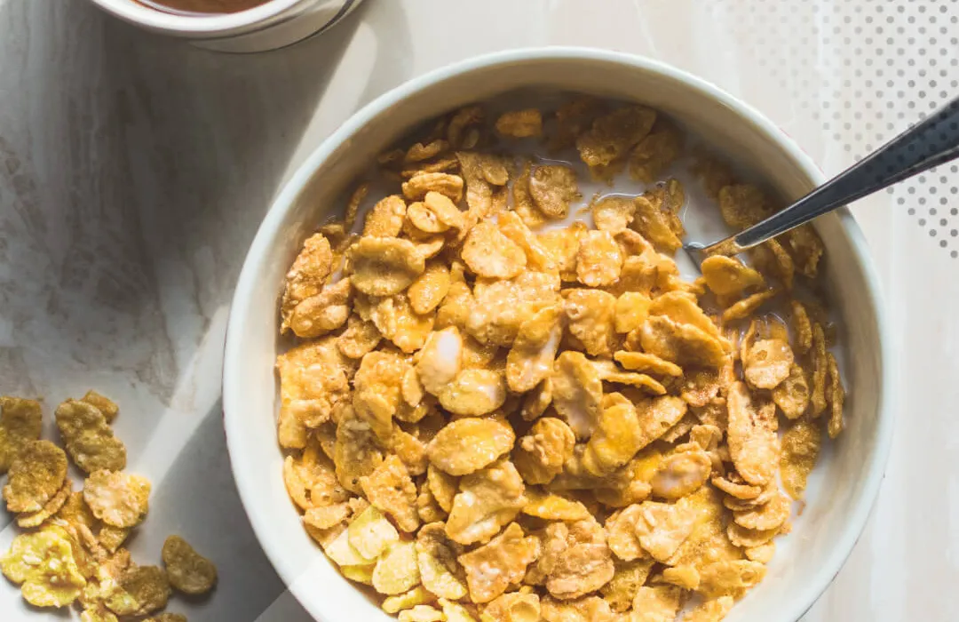 Cornflakes mit Milch in einer weißen Schüssel