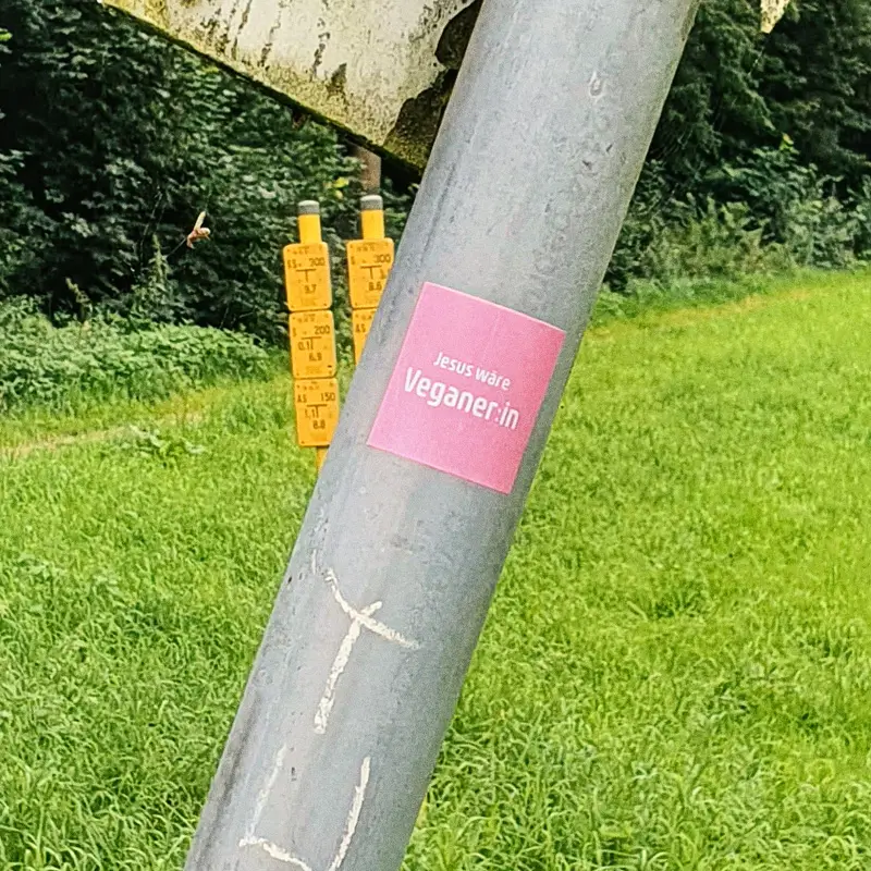 Aufkleber "Jesus wäre Veganer:in" auf Straßenschild